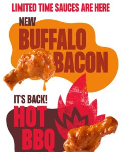 Buffalo Wild Wings hot BBQ sauce and Blazin’ Knockout wings served with fries, ranch dip, and bottled sauces on a wooden table